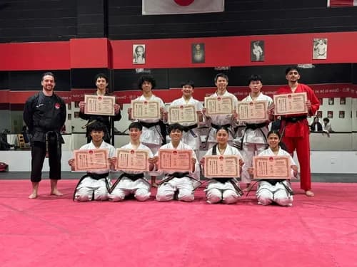 Students celebrating their belt grading with certificates